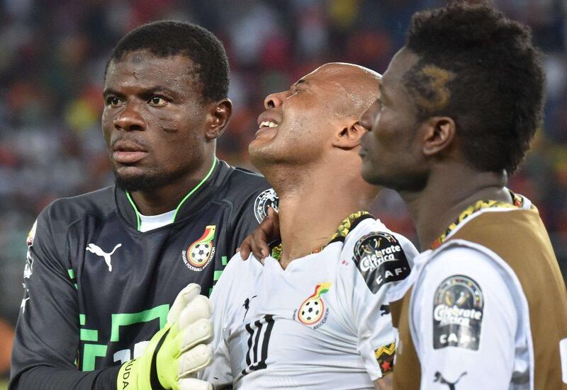 Ghana's Andre Ayew, centre, is comforted by keeper Razak Brimah, left, and Asamoah Gyan, right, after their loss in the Africa Cup of Nations final to Ivory Coast on Sunday. Issouf Sanogo / AFP