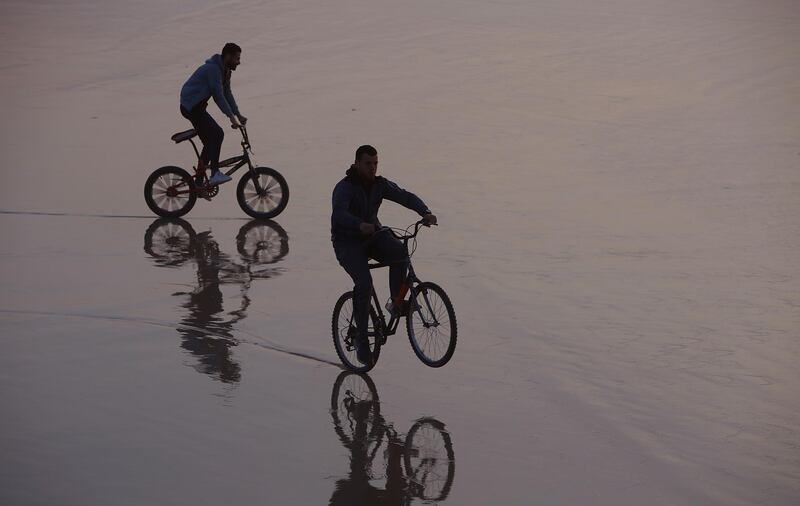 Palestinians ride their bicycles during the sunset at the beach, in Gaza City. AP Photo