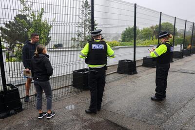 Police officers talk to residents by a newly erected fence in Carbis Bay, ahead of the G7 summit, in Cornwall, Britain, June 5, 2021. REUTERS/Tom Nicholson