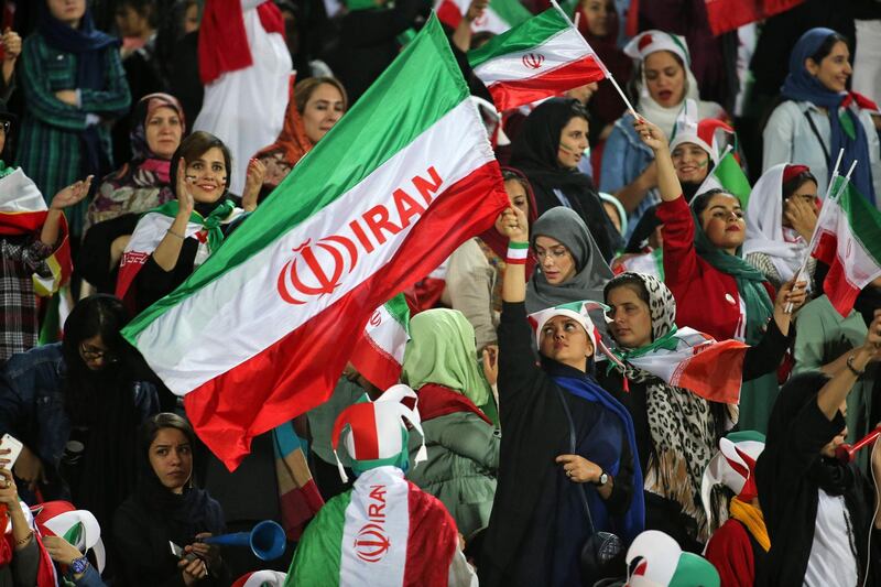 Iranian women cheer ahead of the World Cup Qatar 2022 Group C qualification football match between Iran and Cambodia at the Azadi stadium in the capital Tehran on October 10, 2019. The Islamic republic has barred female spectators from football and other stadiums for around 40 years, with clerics arguing they must be shielded from the masculine atmosphere and sight of semi-clad men. Women fans are attending the football match freely for the first time in decades, after FIFA threatened to suspend the country over its controversial male-only policy.
 / AFP / ATTA KENARE
