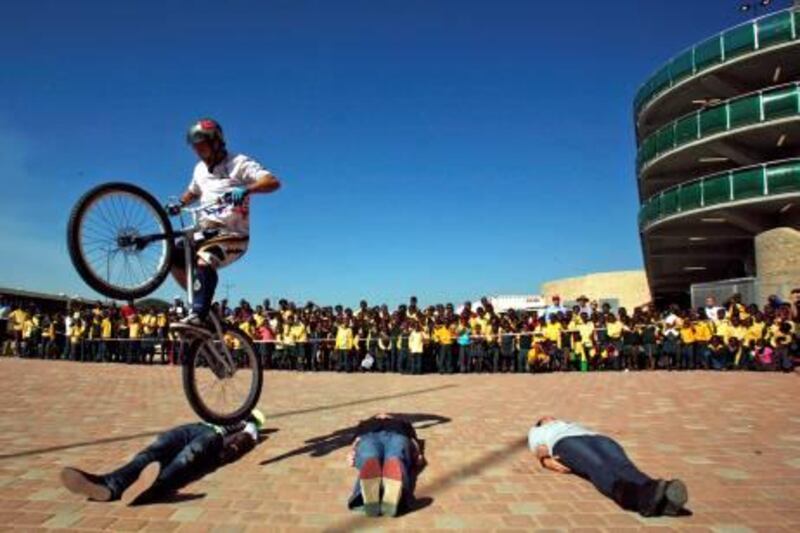 A bicycle rider performs tricks outside the Mbombela Stadium, in Nelspruit, South Africa, Thursday, May 6, 2010. The stadium in the Mpumalanga province is to host several matches in the FIFA World Cup Soccer Tournament which gets under way June 11. (AP Photo/Themba Hadebe)