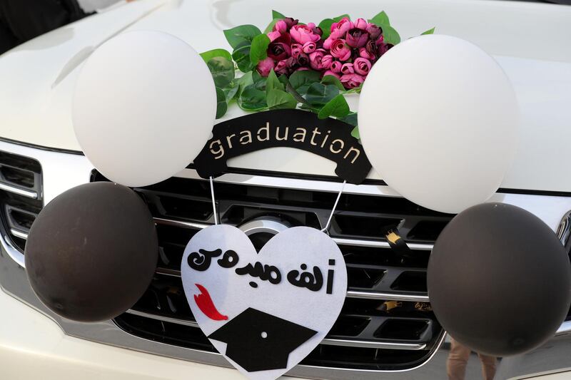 Ajman, United Arab Emirates - Reporter: Anam Rizvi. News. People attach balloons to their cars before the drive through graduation from Ajman University because of Covid-19. Wednesday, February 10th, 2021. Ajman. Chris Whiteoak / The National