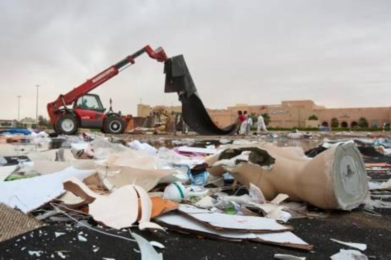 Workers pick up the remains of a Al Khaleej tent souk which fell due to high winds and heavy rain Sunday in Al Ain on Wednesday, April 13, 2011. Pawel Dwulit  /The National