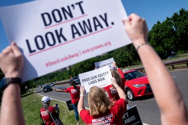 Demonstrators with the group Moms Demand Action hold signs near Ronald Reagan Washington National Airport, as US Senators fly back to town, in Arlington, Virginia, on June 6, 2022.  (Photo by Stefani Reynolds  /  AFP)