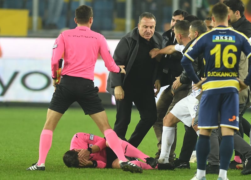 Referee Halil Umut Meler holds his head after being punched. EPA