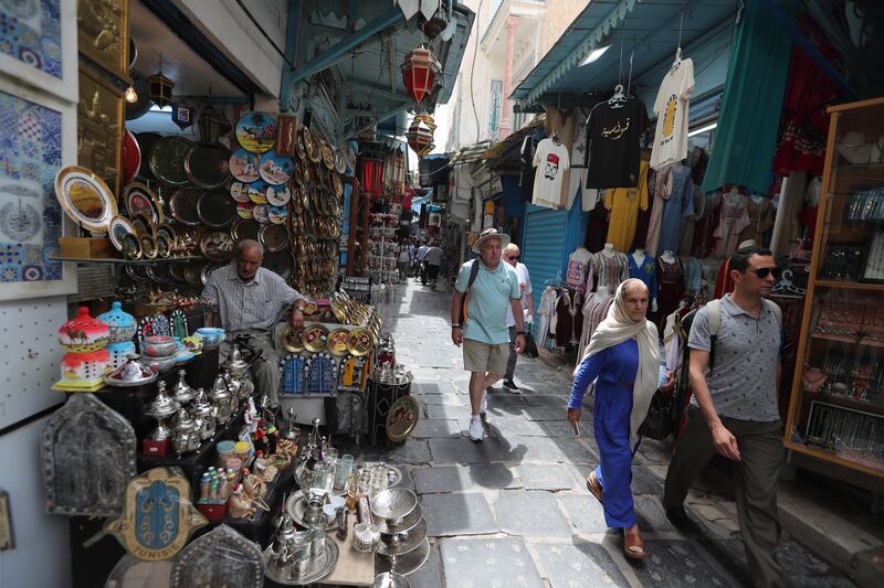 People walk past shops at the old city in Tunis. The IMF expects Tunisia’s economy to grow by 2.2 per cent this year and inflation to rise to 7.7 per cent. EPA