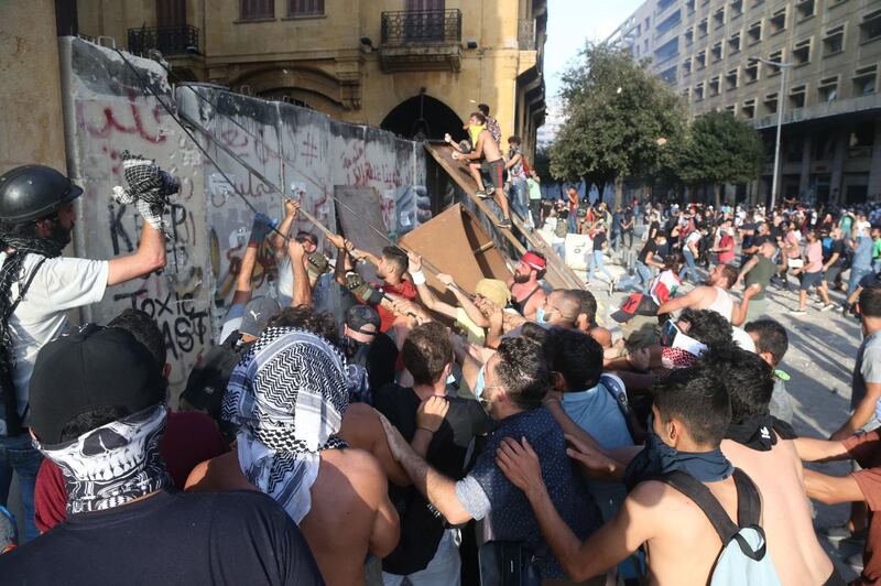 Lebanese anti-government protesters pull a protection wall leading to the Parliament square during a protest in Beirut.  EPA