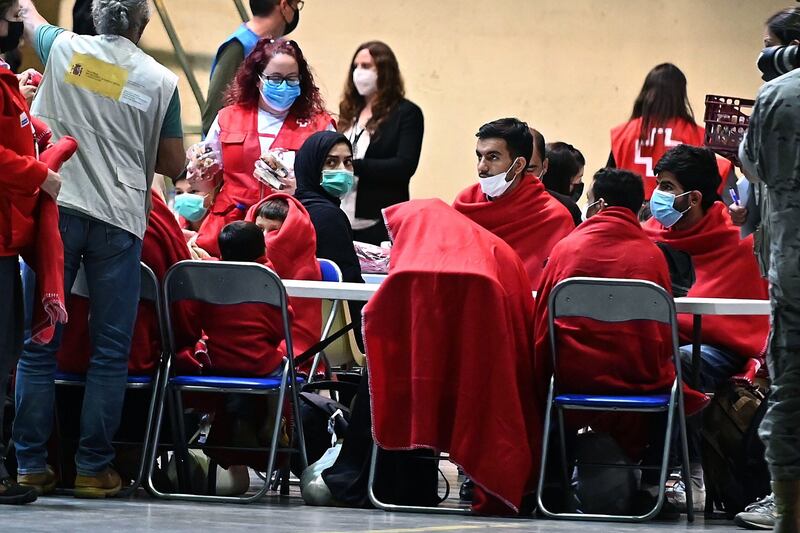 Afghan refugees receive attention from the Spanish Red Cross after arriving at Torrejon de Ardoz military air base in Madrid, Spain. UNHCR said more than 26.4 million people were refugees at the end of 2020. Photo: EPA