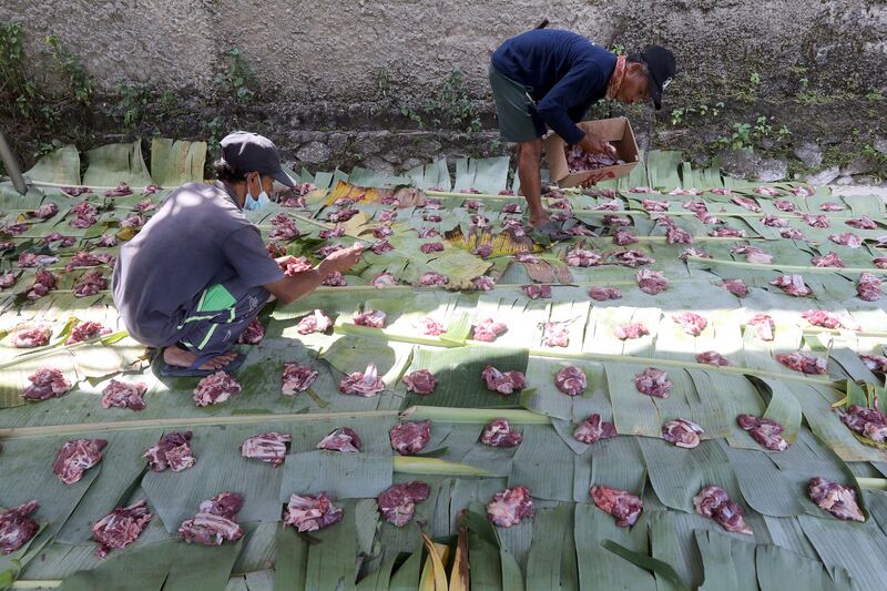 Indonesians arrange pieces of meat before distribution during Eid Al Adha celebrations in Depok, West Java, Indonesia.