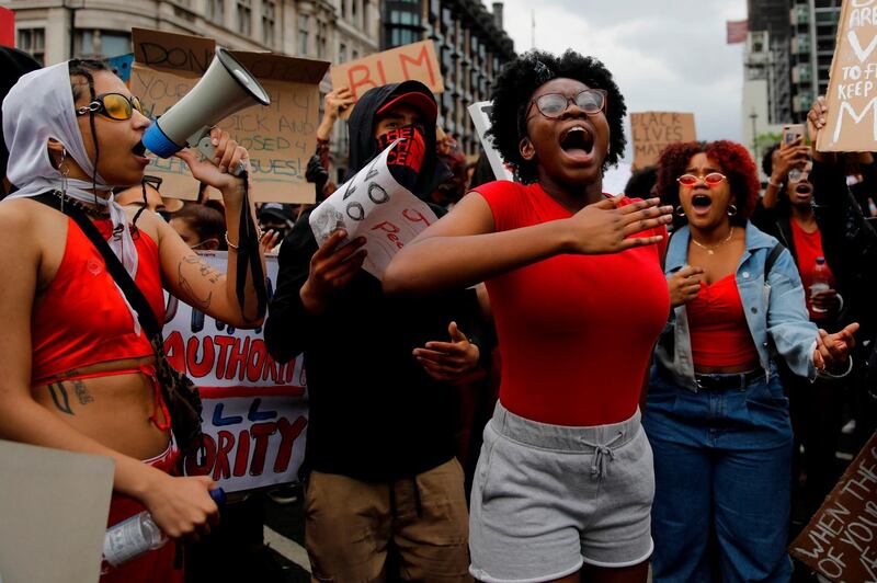 Protestors hold placards and shout slogans as they march during an anti-racism demonstration in central London.  AFP