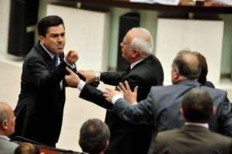 Bengi Yildiz (L), a parliamentarian from the pro-Kurdish Peace and Democracy Party (BDP), reacts as he scuffles with some members of parliament during a debate at parliament in Ankara late April 20, 2010. The parliament in Turkey began debating changes to the constitution on Monday.   REUTERS/Stringer (TURKEY - Tags: POLITICS) *** Local Caption ***  ANK05_TURKEY-_0420_11.JPG