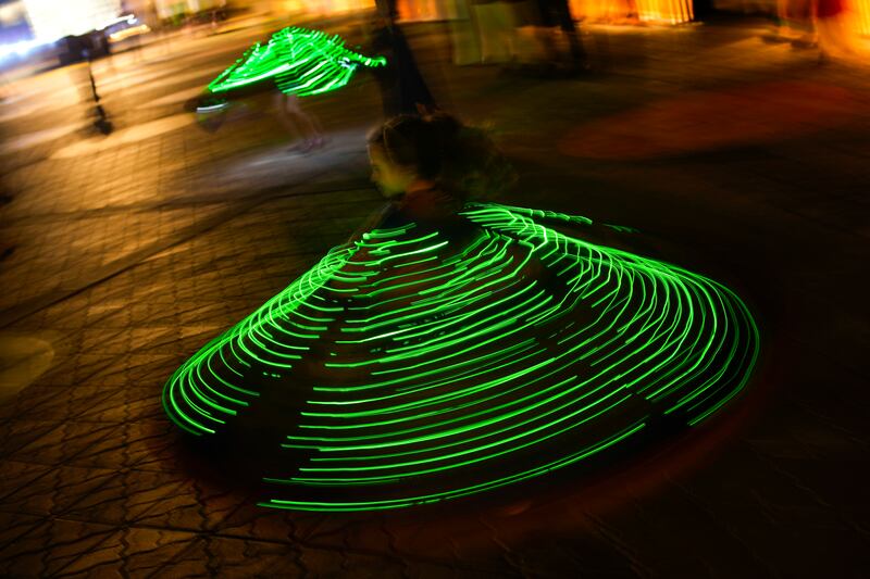 Children wearing illuminated capes dance on the Corniche. AP Photo