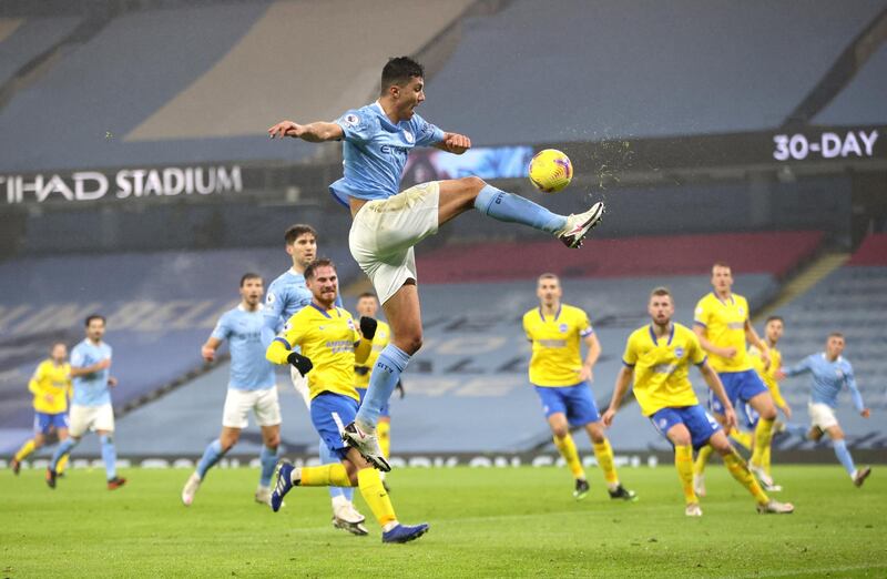 MANCHESTER, ENGLAND - JANUARY 13: Rodrigo of Manchester City stretches as he jumps for the ball during the Premier League match between Manchester City and Brighton & Hove Albion at Etihad Stadium on January 13, 2021 in Manchester, England. Sporting stadiums around England remain under strict restrictions due to the Coronavirus Pandemic as Government social distancing laws prohibit fans inside venues resulting in games being played behind closed doors. (Photo by Clive Brunskill/Getty Images)