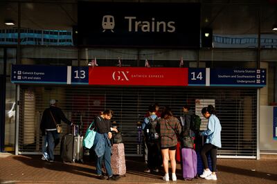Travellers stand outside the closed entrance to the Gatwick Express train service at Victoria Station in London. Reuters