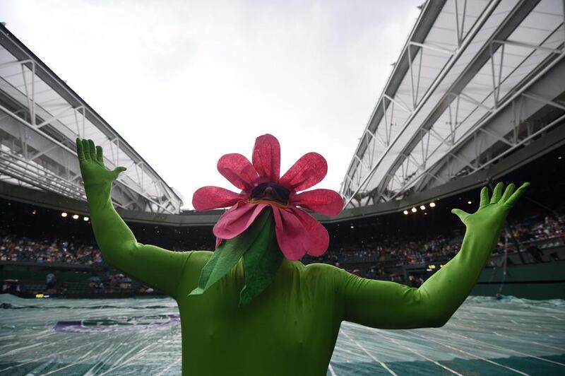 A visitor dressed as a flower as play is postponed on Centre Court due to rain during the 2014 Wimbledon Championships on Monday. Andy Rain / EPA