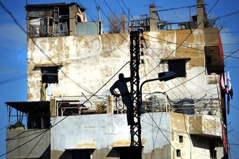 A man fixes electricity wiring outside an appartment building in the northern Lebanese city of Tripoli. AFP / DIMITAR DILKOFF