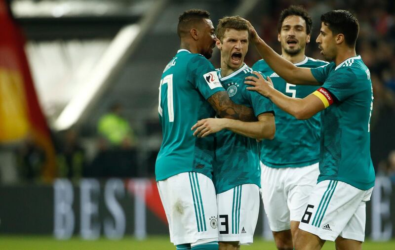 (FILES) In this file photo taken on March 23, 2018, Germany's forward Thomas Mueller (2nd L) is congratulated by his teammates Germany's defender Jerome Boateng (L), Germany's defender Mats Hummels (2nd R) and Germany's midfielder Sami Khedira (R) after scoring the 1-1 during the international friendly football match of Germany vs Spain in Duesseldorf, western Germany, in preparation of the 2018 Fifa World Cup. Germany head coach Joachim Loew dropped a bombshell on March 5, 2019 by announcing that 2014 World Cup winners Jerome Boateng, Mats Hummels and Thomas Mueller are no longer in his plans. / AFP / Odd ANDERSEN
