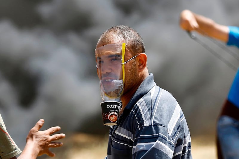 A Palestinian demonstrator covers his face with a makeshift mask. Mohammed Abed / AFP