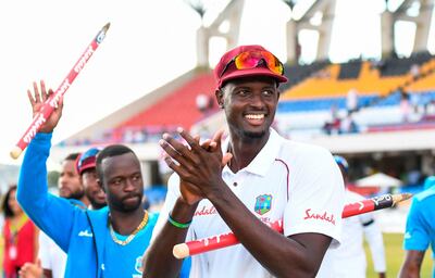 (FILES) In this file photo taken on February 2, 2019 Jason Holder (R) of West Indies celebrates winning on day 3 of the 2nd Test between West Indies and England at Vivian Richards Cricket Stadium in North Sound, Antigua and Barbuda. West Indies captain Jason Holder has been suspended for the third and final Test against England due to his team's slow over-rate during their victory in Antigua last week, the ICC announced on February 4, 2019. Cricket's governing body banned Holder, despite the hosts playing four seamers and the regular fall of wickets as England were bowled out for 187 and 132.The ICC said in a statement that the Windies were two overs short of their target for the match.
 / AFP / Randy Brooks
