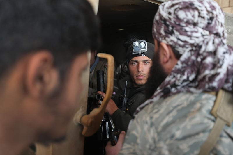 TOPSHOT - Members of the "Syrian National Army", an alliance of Turkey-backed rebel groups, ride in an armoured personnel carrier (APC) in the town of Sarmin, about 8 kilometres southeast of the city of Idlib in northwestern Syria, on February 24, 2020, as they take part in a military offensive on the village of Nayrab following an artillery barrage fired by Turkish forces.  / AFP / Omar HAJ KADOUR
