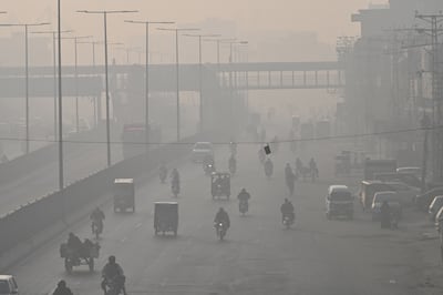 Commuters make their way along a smoggy street in Lahore on Wednesday. AFP