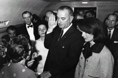 Lyndon B Johnson sworn in as the 36th president of the United States on board Air Force One, after the assassination of President John F Kennedy, on November 22, 1963. His wife, Lady Bird, left, and the grief-stricken first lady, Jackie Kennedy, look on. Keystone / Getty Images