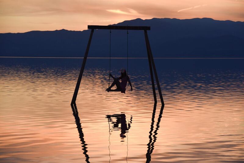 An attendee on a swing installed in the Salton Sea on the first day of the Bombay Beach Biennale, in Bombay Beach, California. AFP