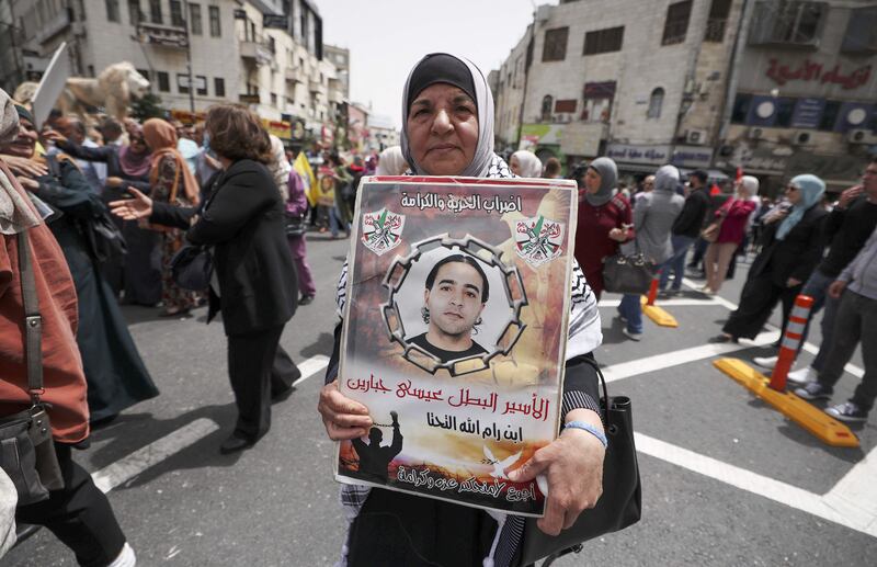 A woman in Ramallah in the West Bank carries a poster bearing the image of a jailed man during a demonstration marking Palestinian Prisoners’ Day. AFP