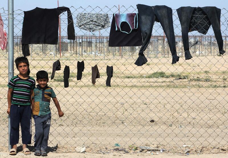 Displaced Iraqi children stand next to a washing line in a camp for internally displaced people near al-Khalidiyeh in Iraq's western Anbar. While the election campaign is in full swing elsewhere in Iraq, the country's displaced camps barely register on the radars of those running for office, despite housing hundreds of thousands of people. Ahmad Al Rubaye / AFP