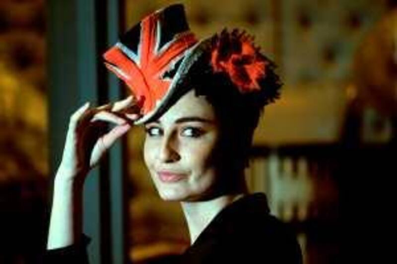 Model Erin O'Connor models a brightly coloured couture hat at the Victoria and Albert Museum in London.