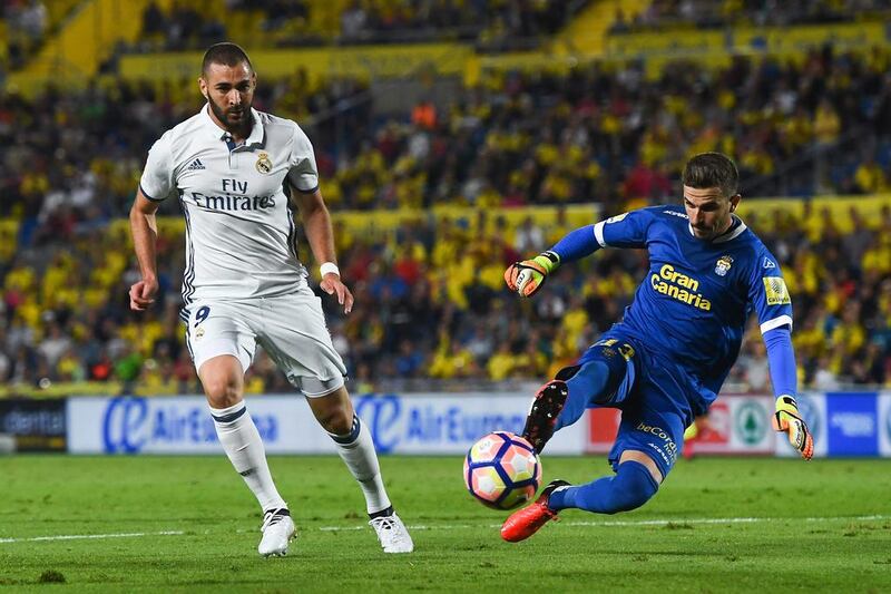 Javi Varas of Las Palmas clears the ball under a challenge by Karim Benzema. David Ramos / Getty Images