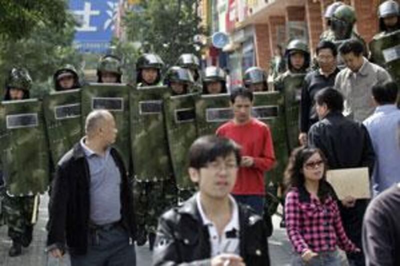 Chinese security forces clear the crowds after a reported syringe stabbing incident near The People square in Urumqi.