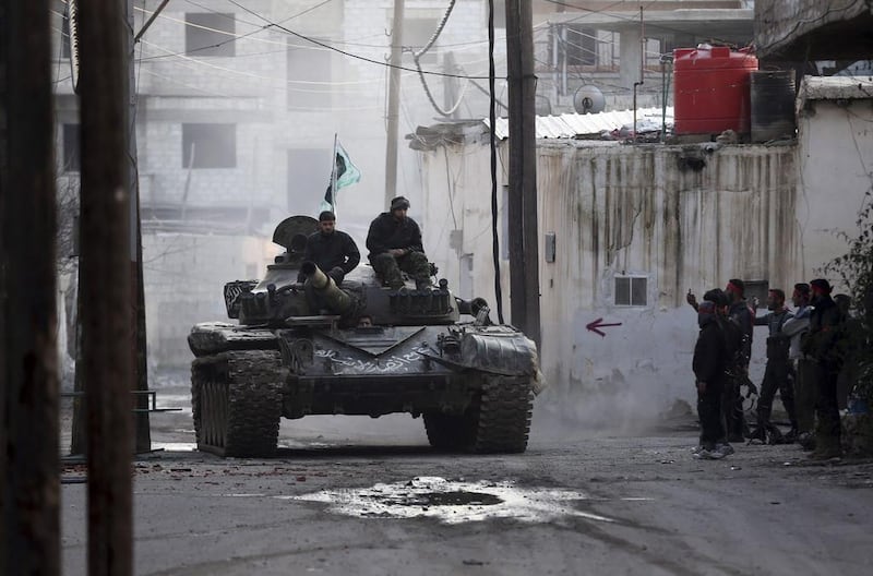 Free Syrian Army fighters ride on a tank outside a Syrian army base during heavy fighting in the Arabeen neighbourhood of Damascus. Goran Tomasevic / Reuters