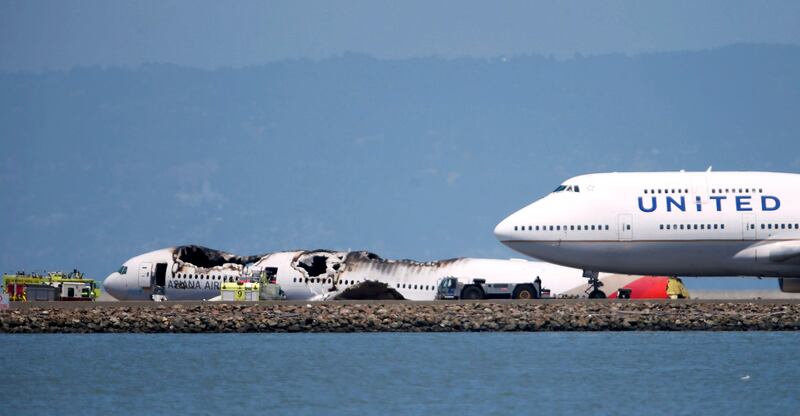 An airliner passes the wreckage of an Asiana Airlines Boeing 777 which crash landed at San Francisco International Airport in San Francisco, California July 6, 2013.         REUTERS/Stephen Lam (UNITED STATES  - Tags: DISASTER TRANSPORT)   *** Local Caption ***  SFO113_WEB-SFOCRASH_0706_11.JPG