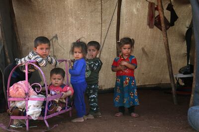 TOPSHOT - Syrian children stand outside a tent next to a metal crib at a camp for displaced civilians fleeing from advancing Syrian government forces, close to a Turkish military observation point near the village of Surman in the rebel-held northwestern Idlib province on September 5, 2018. (Photo by Amer ALHAMWE / AFP)