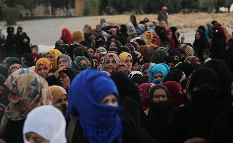 Women stand together as they receive aid donated by the Turkish Red Crescent in the border town of Tal Abyad, Syria. Reuters