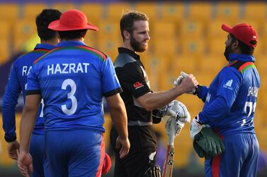 Afghanistan's Mohammad Shahzad (R) greets New Zealand's captain Kane Williamson at the end of the ICC men’s Twenty20 World Cup cricket match between New Zealand and Afghanistan at the Sheikh Zayed Cricket Stadium in Abu Dhabi on November 7, 2021.  (Photo by INDRANIL MUKHERJEE  /  AFP)