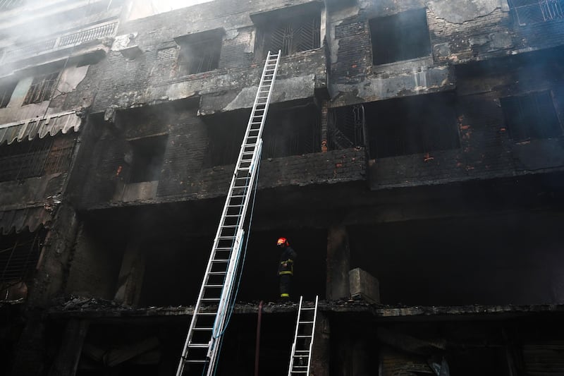 A firefighter inspects a burnt building after the fire broke out in Dhaka. AFP