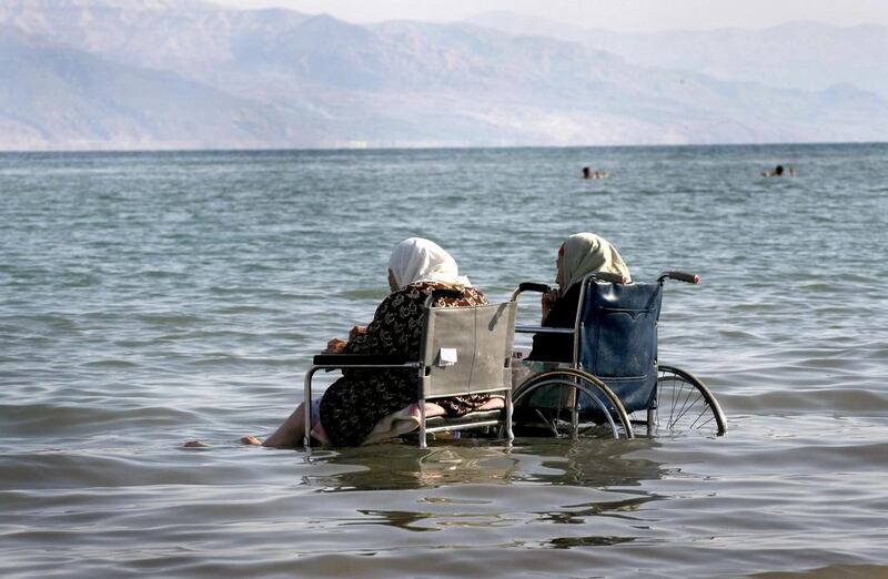 Palestinian women in wheelchairs take the waters of the Dead Sea. Menahem Kahana / AFP