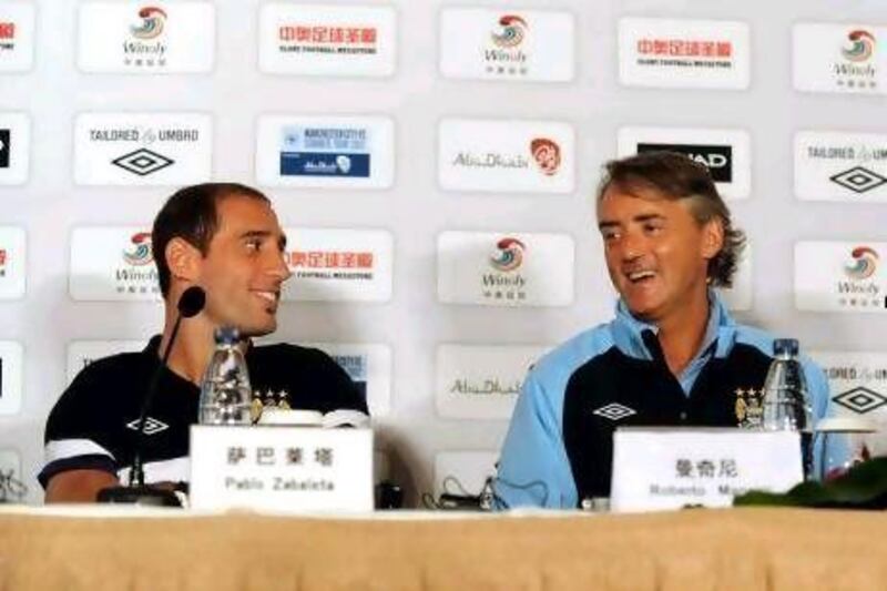 Manchester City manager Roberto Mancini, right, is urging the club's to make new signings.
