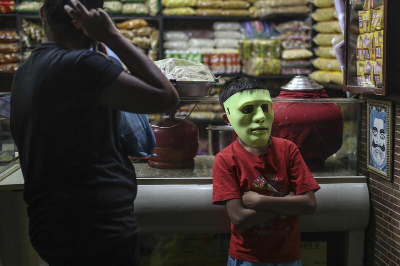 A child wears a green costume mask at a store in Mumbai, India. Dhiraj Singh/Bloomberg