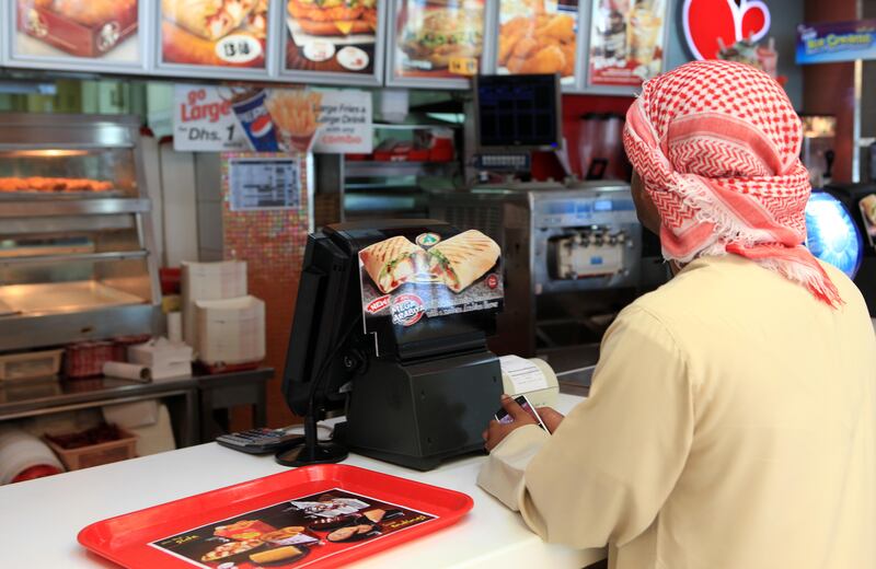 ABU DHABI - 30DEC2010 - A customer waits at KFC counter on Sheikh Rashid bin Maktoum street in Abu Dhabi. Ravindranath K / The National