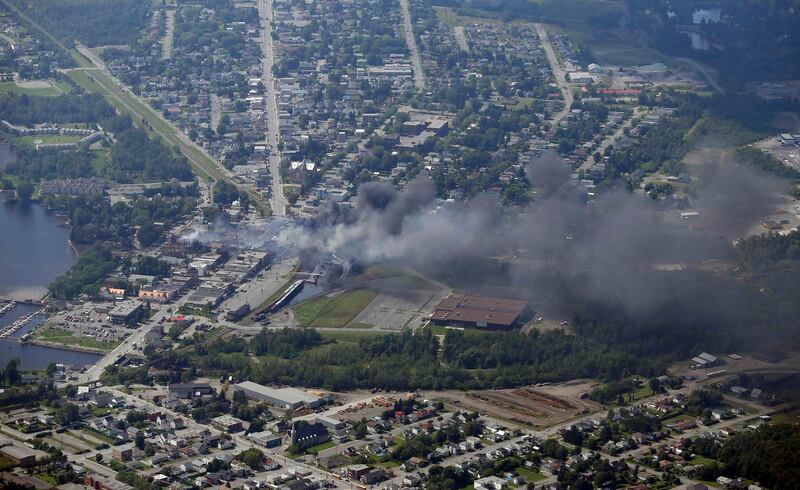 Smoke rises after a train explosion in the town Lac Megantic July 6, 2013. Several people were missing after four tank cars of petroleum products exploded in the middle of a small town in the Canadian province of Quebec early on Saturday in a fiery blast that destroyed dozens of buildings.  REUTERS/Mathieu Belanger (CANADA - Tags: DISASTER ENERGY) *** Local Caption ***  QUE19_CANADA-TRAIN-_0706_11.JPG