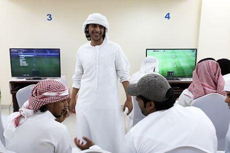 Mohammed Saeed Abdullah Al Ameri, standing, has been all smiles after his matches on Pro Evolution Soccer 2013 during the Million Player challenge at Abu Dhabi.