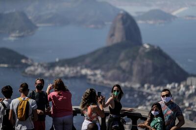 epa08605963 Tourists visit the Christ the Redeemer during its reopening to tourism, in Rio de Janeiro, Brazil, 15 August 2020. Rio de Janeiro has reopened touristic hotspots as the Sugarloaf Mountain, the aquarium, and the giant waterwheel despite warnings for the increase of coronavirus spread in the city.  EPA/Antonio Lacerda