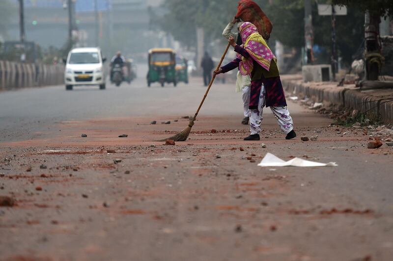 A man sweeps a road after the previous day's protest against the India's new citizenship law in New Delhi. AFP