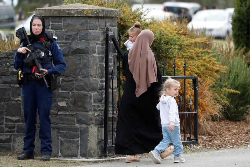 A policewoman is seen as people attend the burial ceremony of a victim of the mosque attacks, at the Memorial Park Cemetery in Christchurch. Reuters