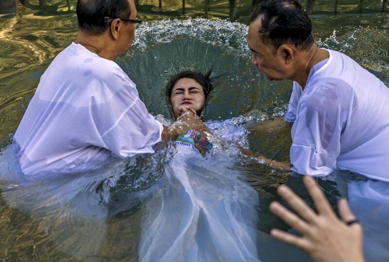 A Christian pilgrim from Indonesia is baptised during a ceremony in the waters of the Jordan River at Yardenit in northern Israel. AFP