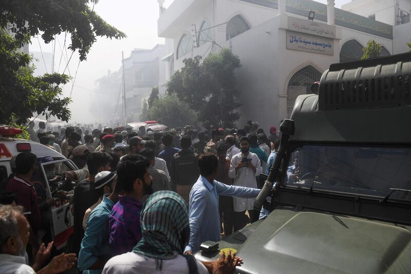 Rescue workers and people gather near the site of the crash. AFP