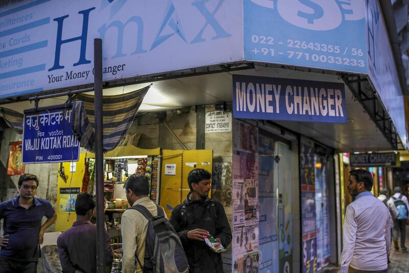 Pedestrians walk past by a currency exchange store in Mumbai, India, on Thursday, June 28, 2018. The rupee, the worst performing currency in Asia this year, touched a record low at 69.0925 per dollar on Thursday as gains in oil prices threatened to stoke inflation and worsen the nations domestic and external finances. Photographer: Dhiraj Singh/Bloomberg